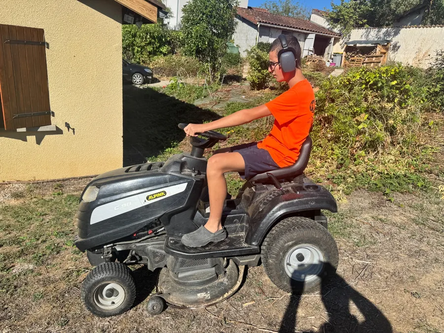 Tom utilisant une tondeuse autoportée